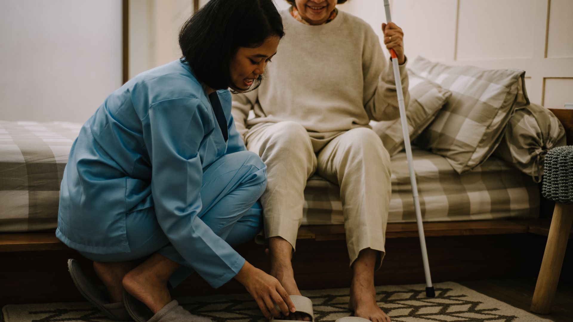 Caregiver assisting elderly person with cleaning and mobility at home