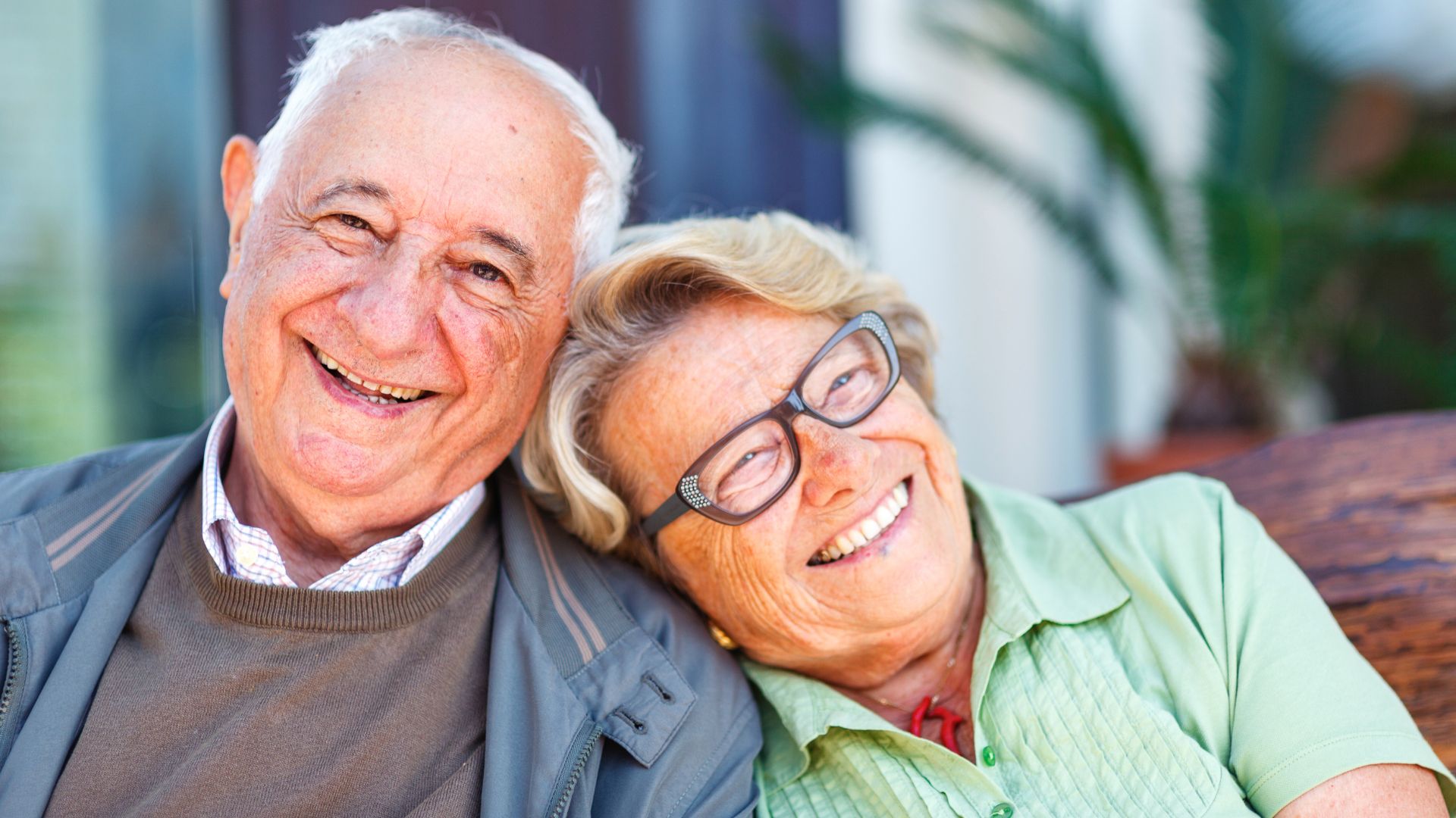 Happy elderly couple smiling together, leaning close with warm embrace