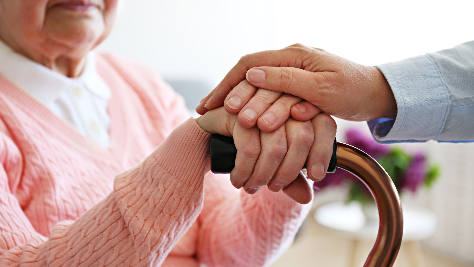 Hands holding supportive comfort, elderly person with walking cane