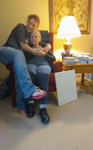 Two people sitting closely together on a cozy armchair at home